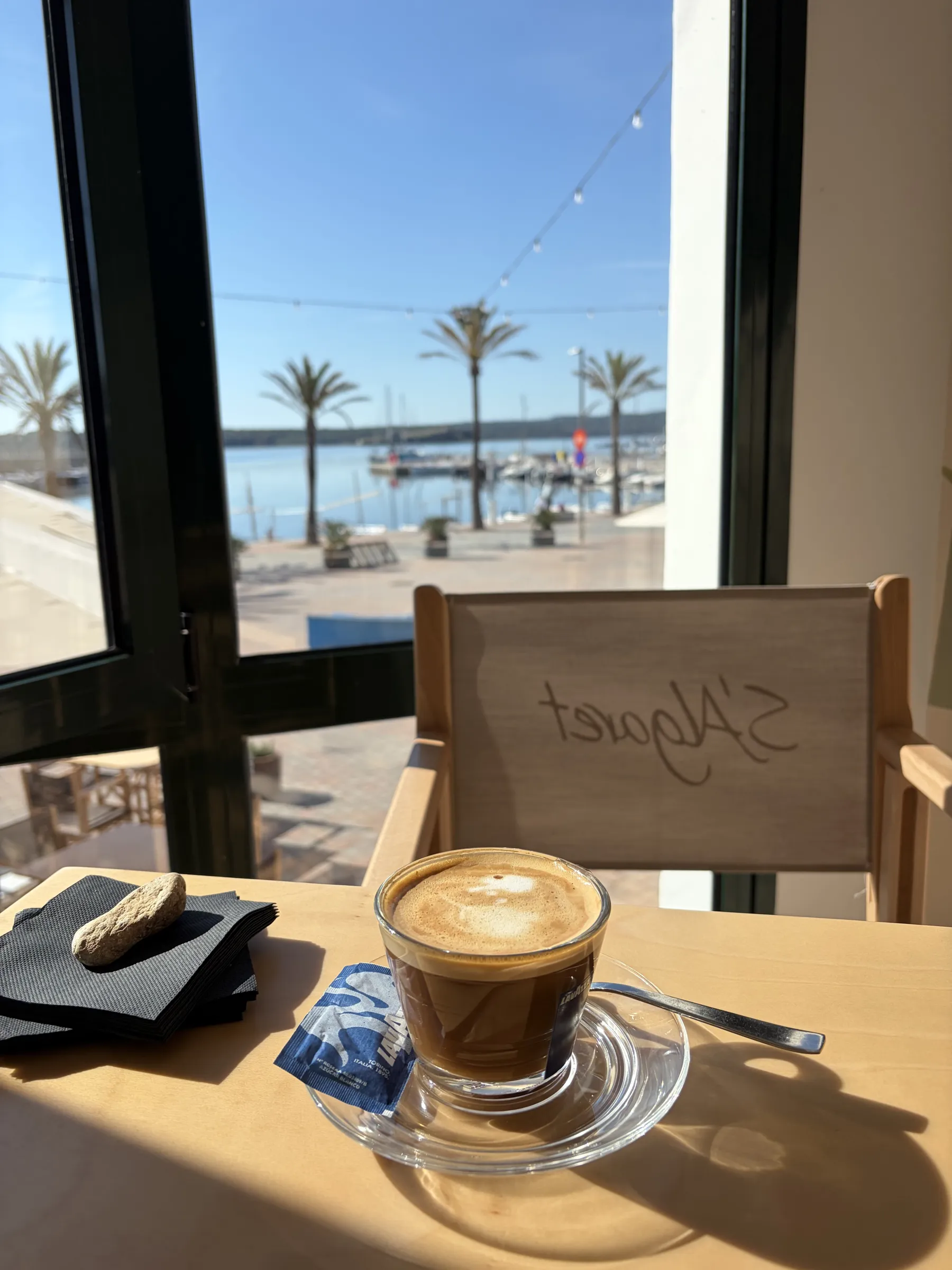 Café en una mesa junto a la ventana del Hotel S'Algaret, Fornells