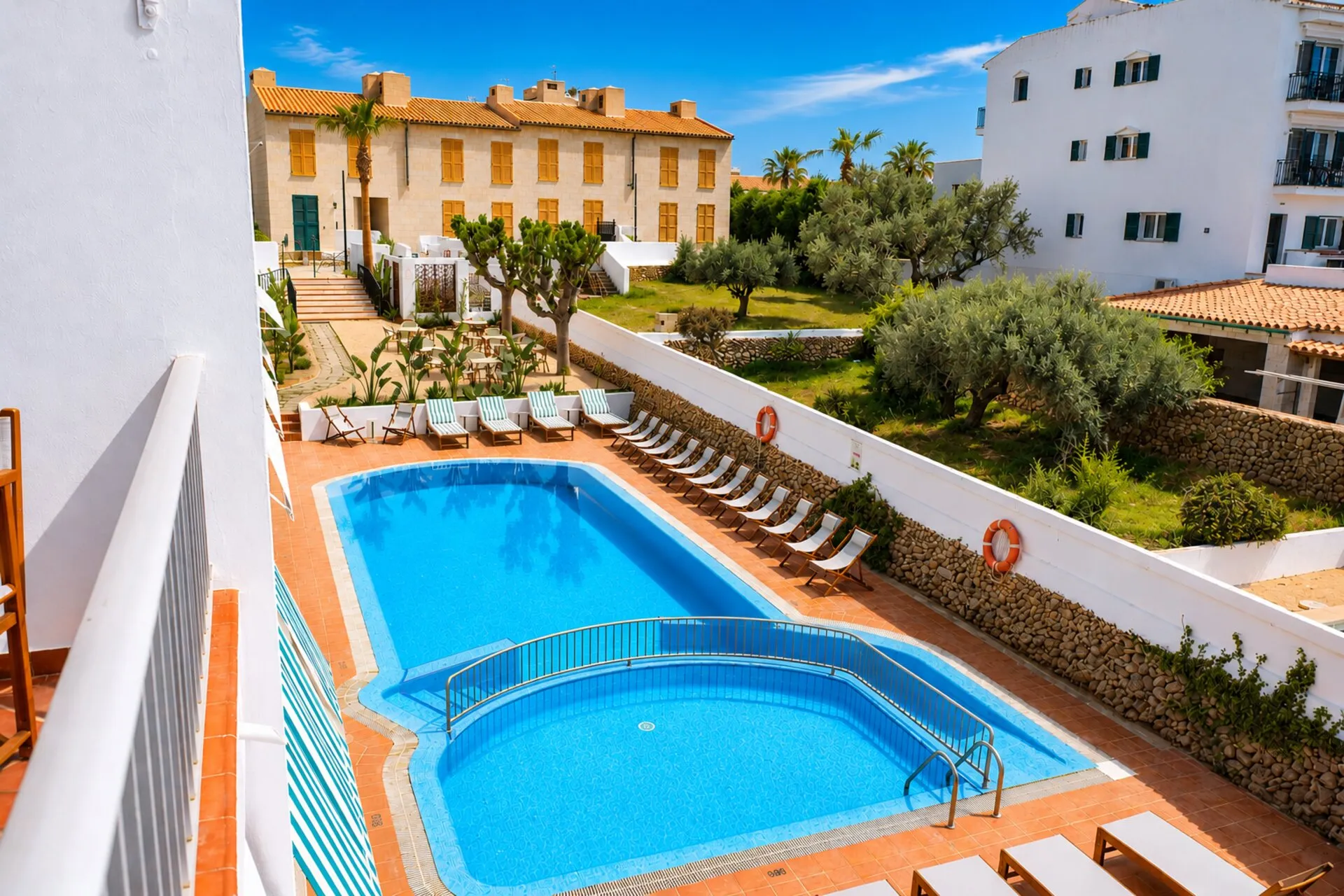 Piscina y jardín del Hotel S'Algaret vistos desde un balcón